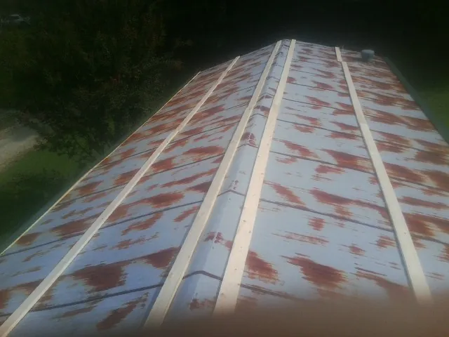 Rusted metal roof panels with new wood purlins before replacement — Storm Damage Roof Repair in Hamlin by Roofing Brothers
